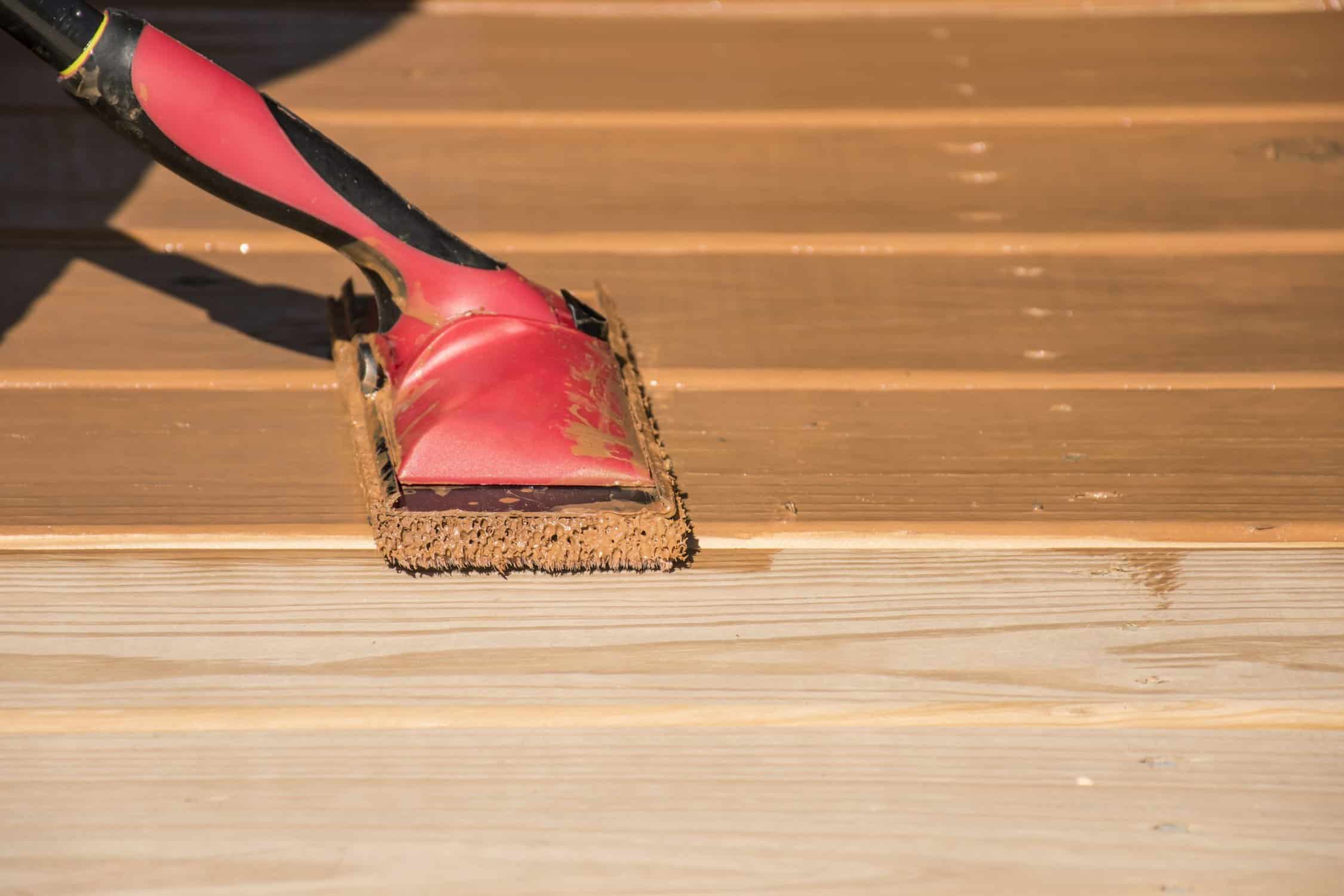 Wood Deck Staining Street view of a row of houses. The front of each house has a porch, stairs and a sidewalk.