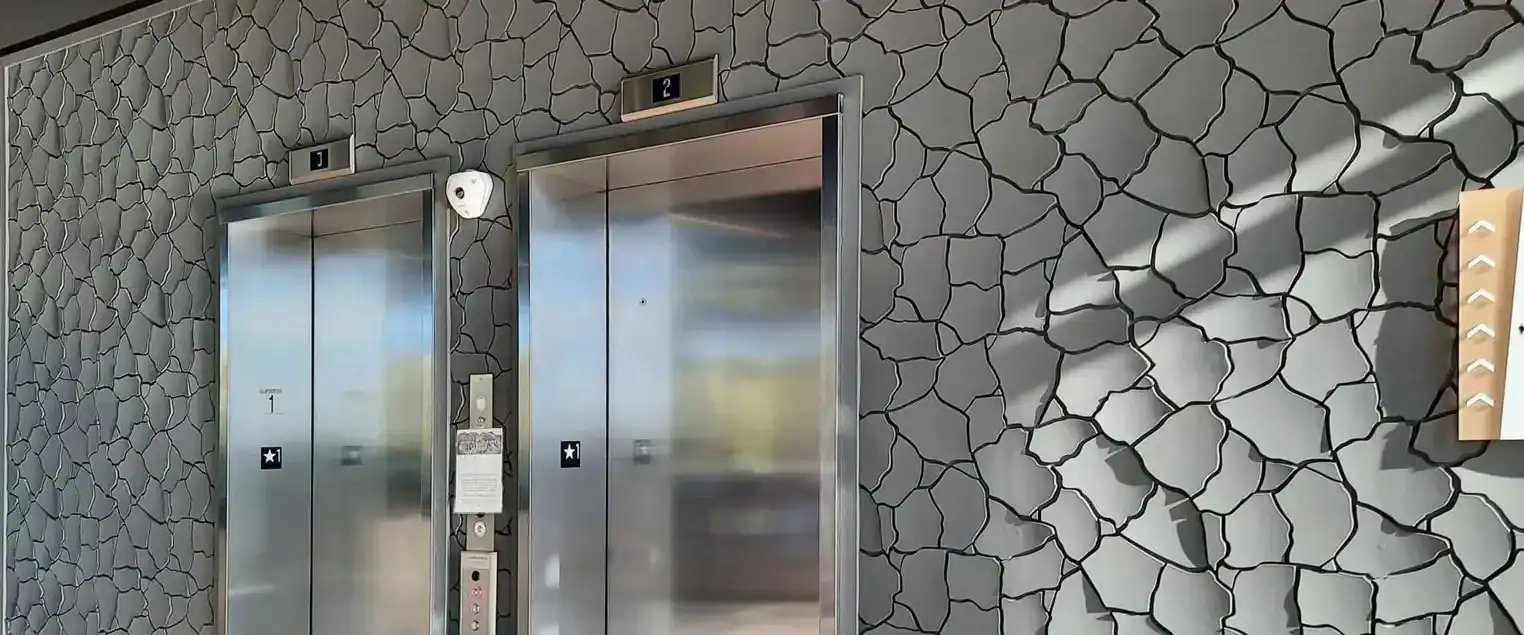 Elevator Lobby Faux Finish Texture Painting An elevator lobby featuring a unique stone like textured faux finish on the walls.