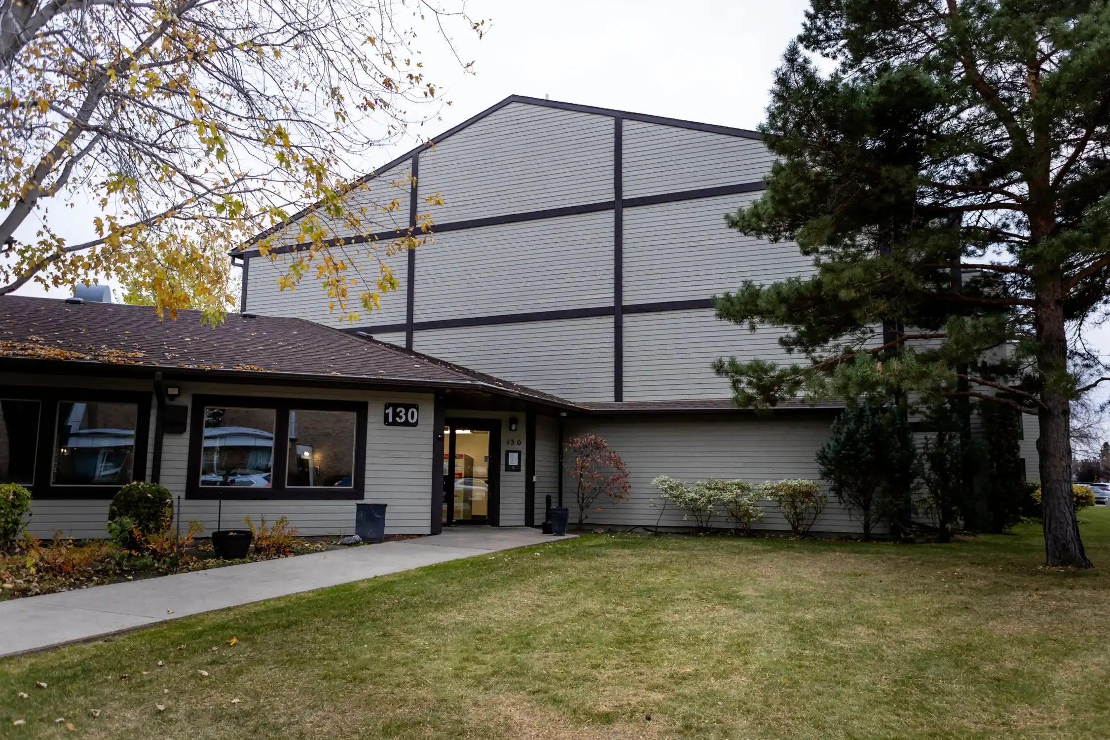 Condo and Apartment Building Exterior Painting Front view of a multi family condo building with light gray siding, dark trim, and a welcoming entrance.