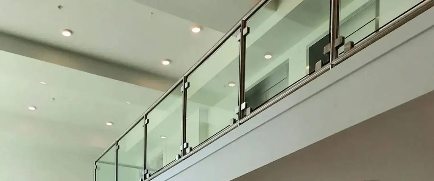 Commercial and Multi Family Interior Painting Modern interior space with glass railings and high ceilings, showcasing clean, light painted walls and ceilings.