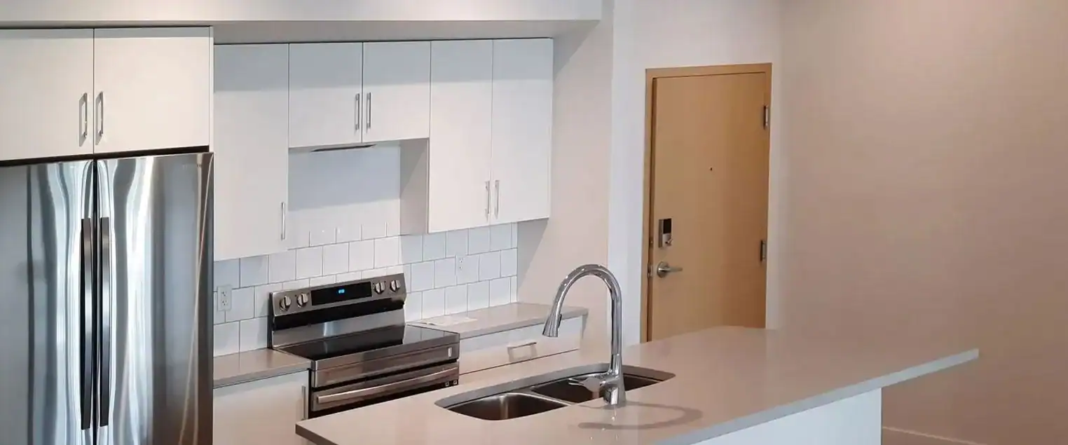 Apartment Kitchen Cabinet and Wall Painting Modern apartment kitchen island with a sink, stainless steel appliances, and clean, light painted walls.