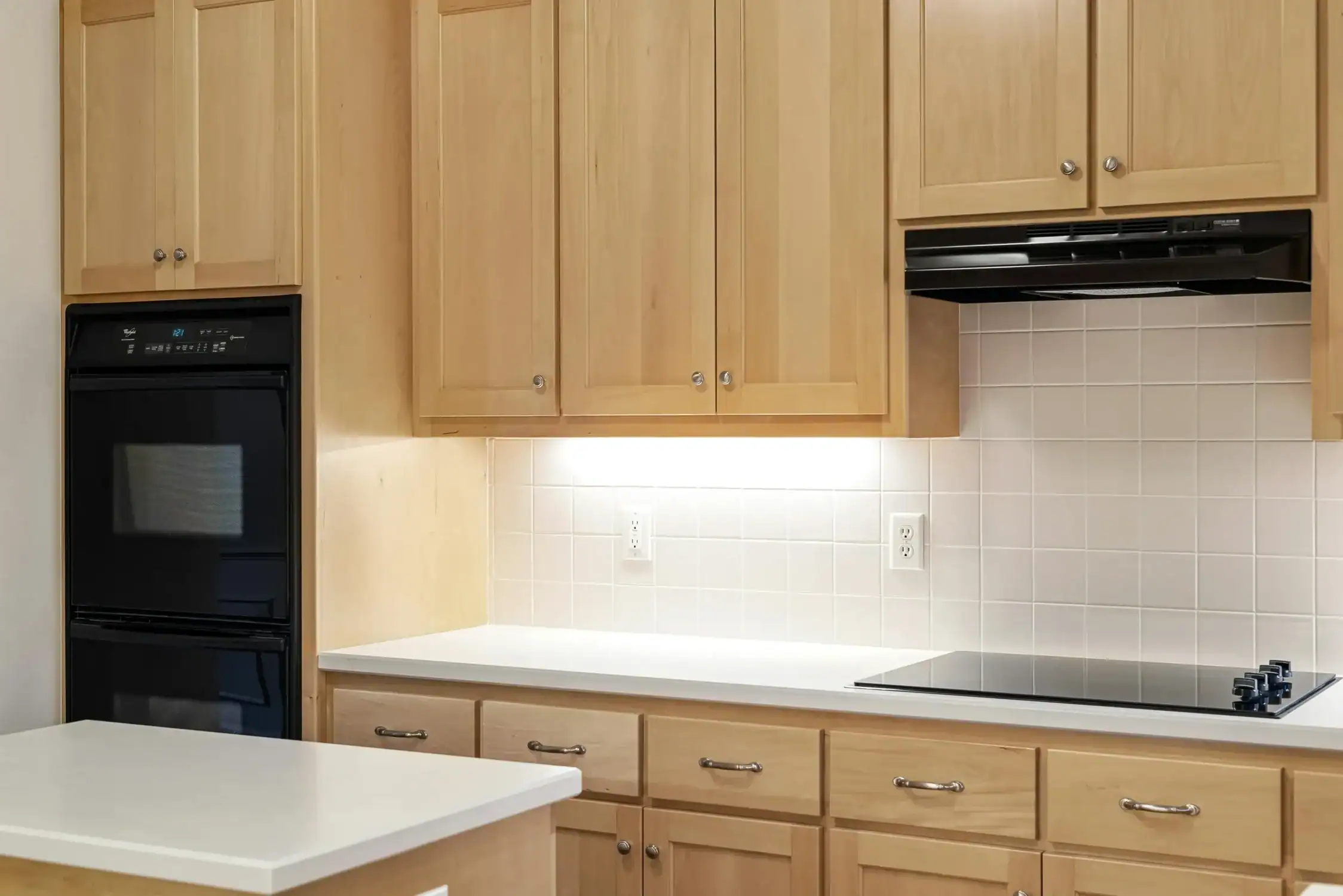 Modern Kitchen with Light Wood Cabinets A modern kitchen featuring light wood cabinets, white countertops, and stainless steel appliances.