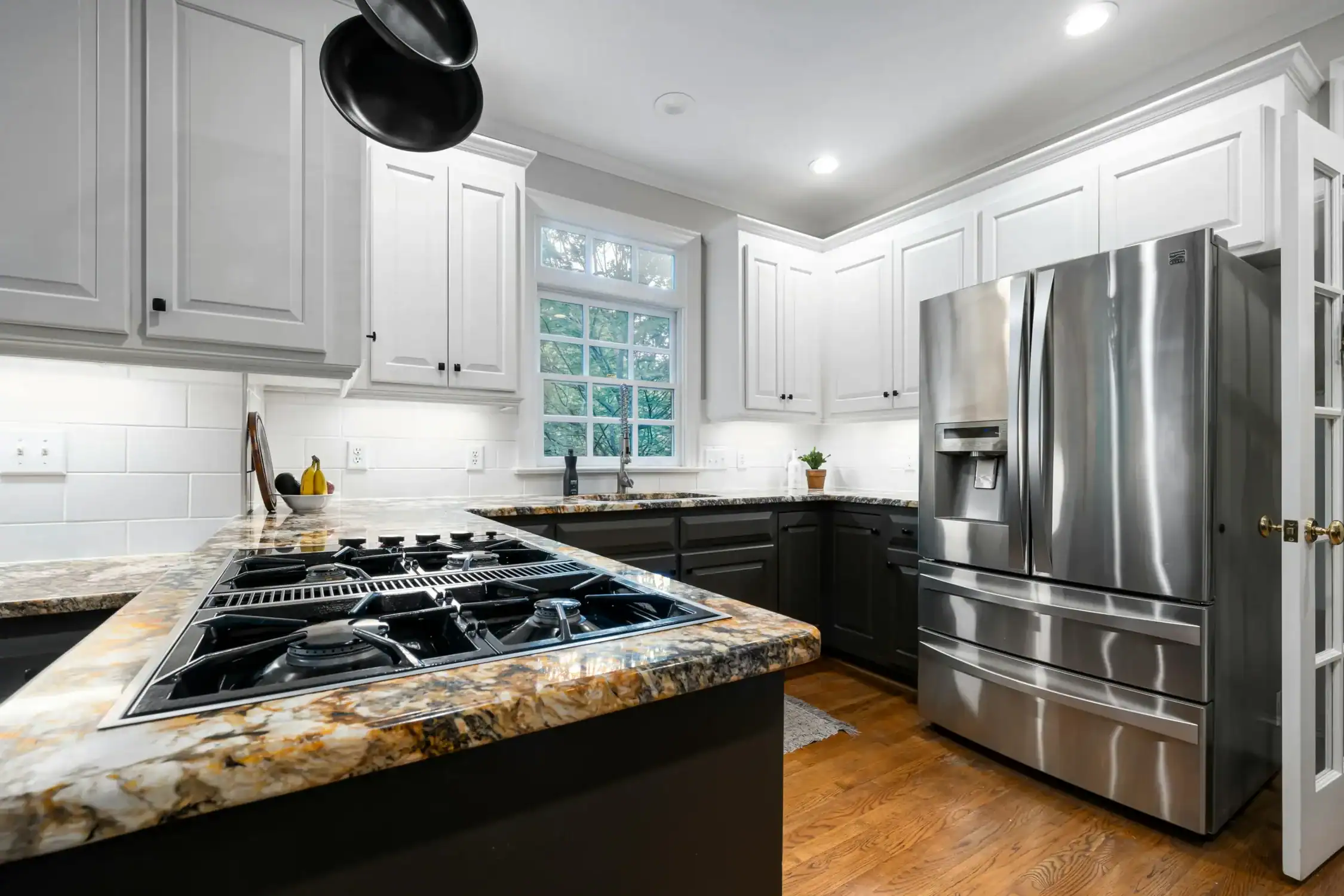 Residential Kitchen Cabinet Painting and Modernization Modern residential kitchen with freshly painted two toned cabinets, stainless steel appliances, and granite countertops.