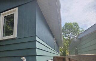 The side of a house with blue siding, showing a fresh paint job and clean lines.