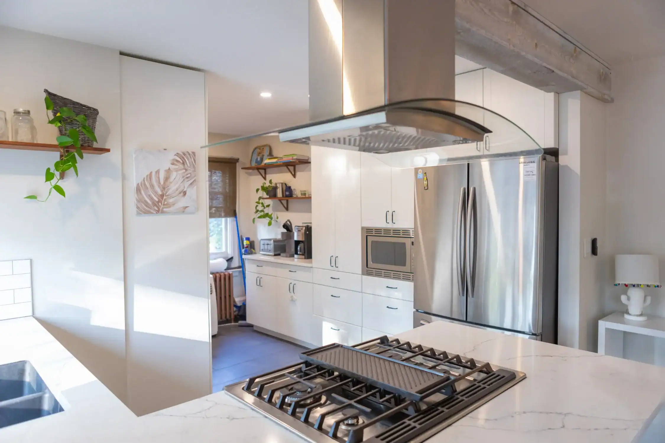 Modern Kitchen Interior Painting and Cabinet Refresh Bright modern kitchen with white cabinets, stainless steel appliances, and a central island, featuring freshly painted walls.