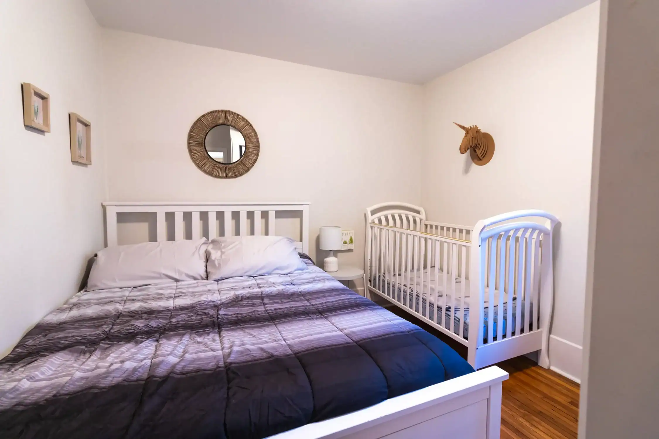 Complete Bedroom Interior Painting Solutions Residential bedroom featuring a large bed and a crib, with clean, light painted walls, highlighting quality interior painting.