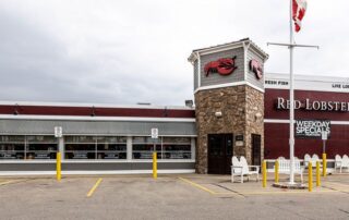A wide exterior view of a Red Lobster restaurant, highlighting the freshly painted facade and stone elements.