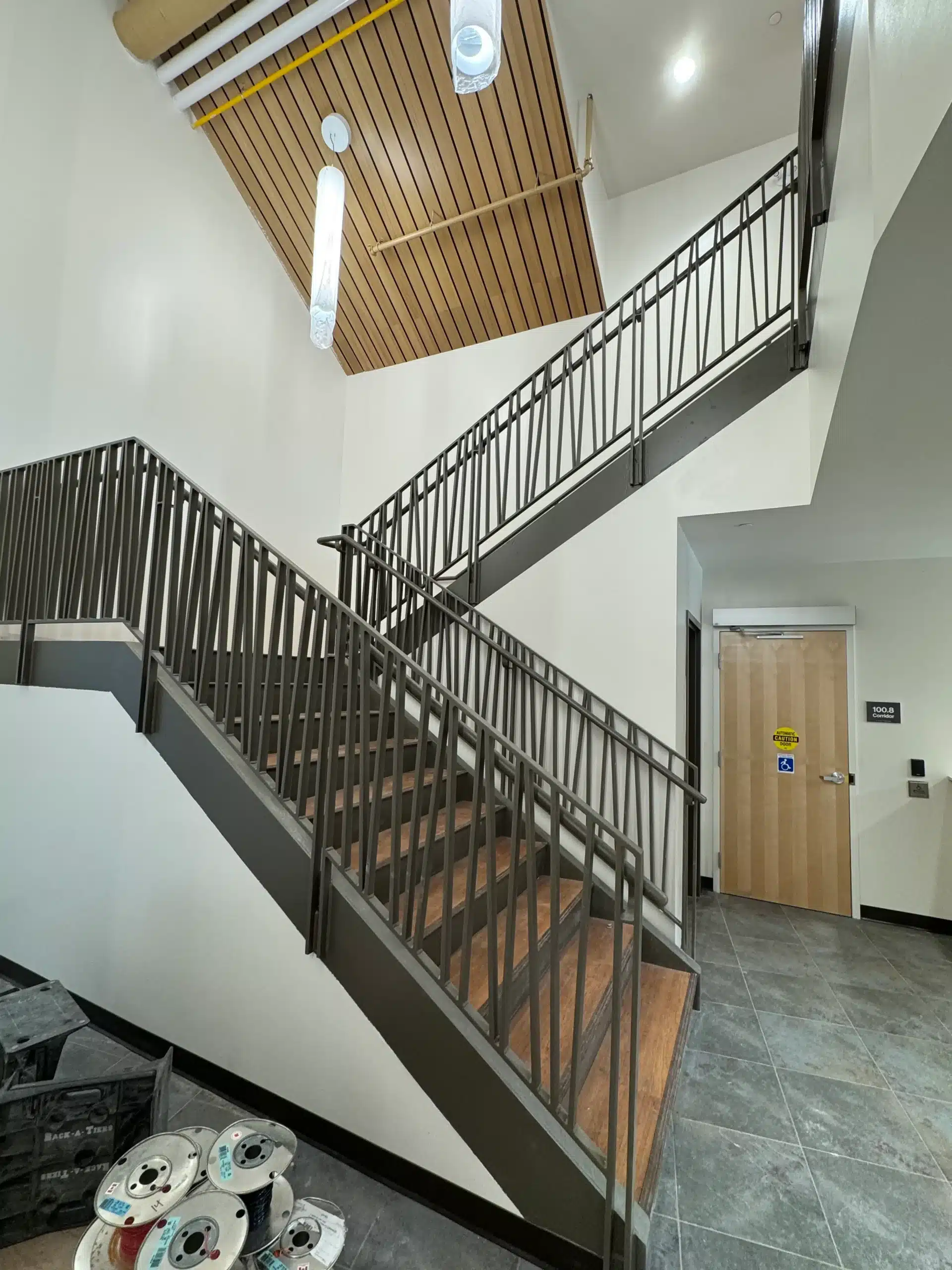 Modern Commercial Interior with Freshly Painted White Walls and Staircase A modern commercial building interior features a large staircase with dark railings and freshly painted white walls.